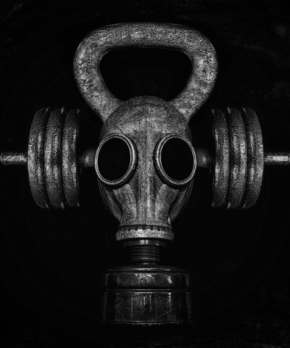 Bold monochrome composition of kettlebells and dumbbells forming a striking mask — the unconventional, high-intensity BENSCHIZO aesthetic.